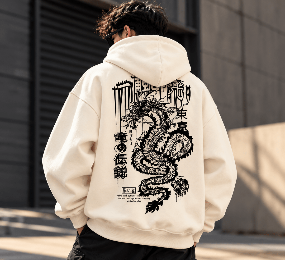 TEEZO off-white oversized hoodie with bold black Japanese dragon graphic and Japanese-inspired typography on the back, worn by a male model.