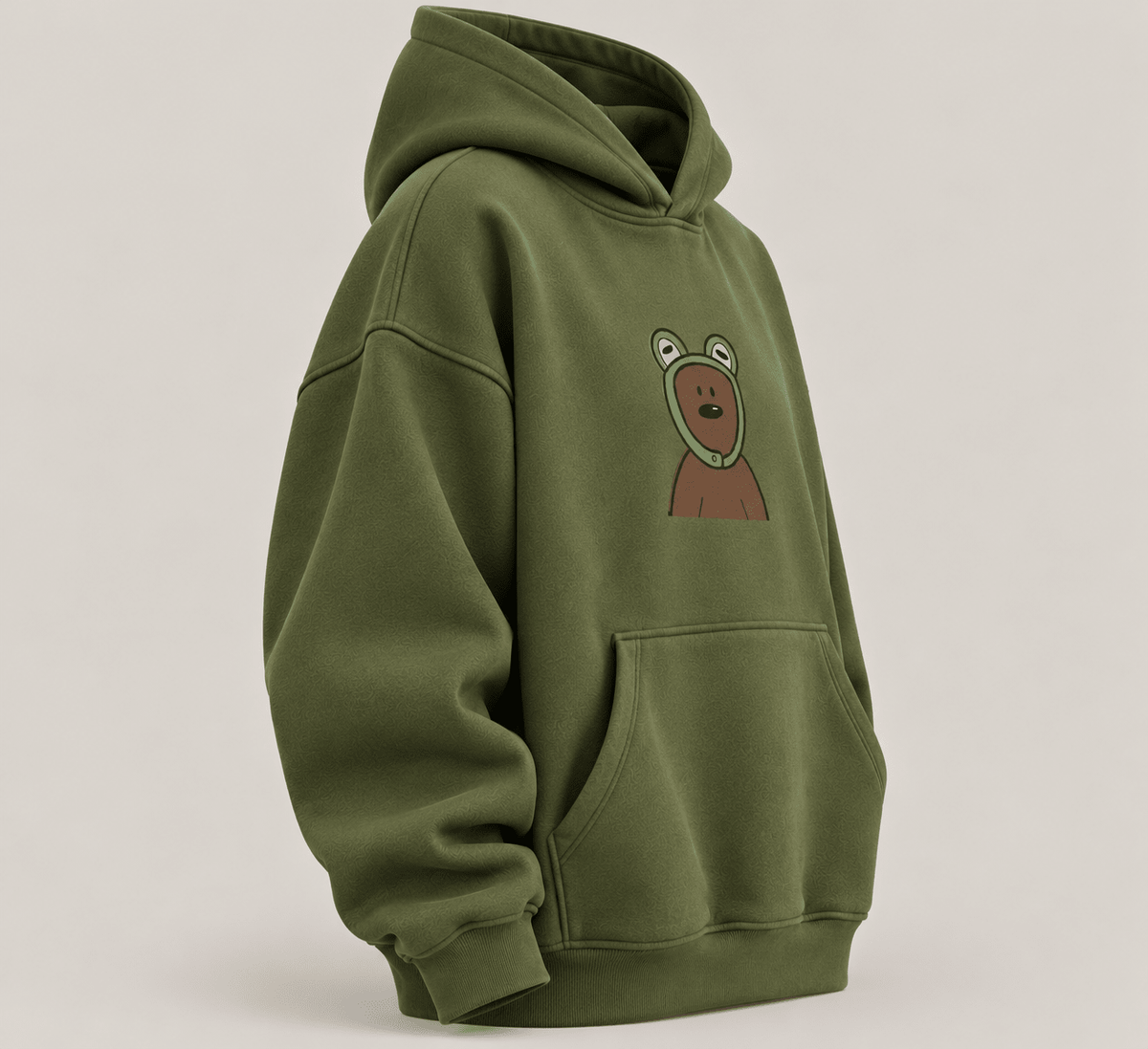 TEEZO olive green oversized hoodie with a cute cartoon bear graphic on the front, styled on a female model in a casual indoor setting.